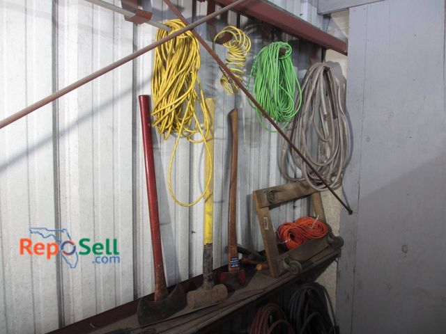 Lot 31-1316 - Includes A Variety Of Yard Tools Such As Axes And Sledgehammer, Coiled Hoses In Multiple Colors, And...