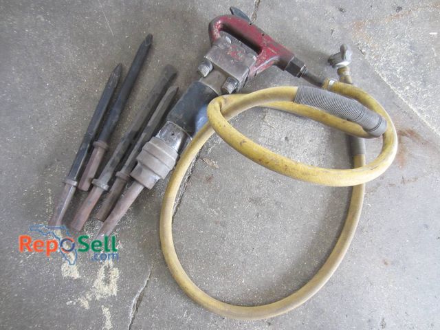Lot 31-1371 - Pneumatic jackhammer featuring a red metal body and attached yellow air hose. Includes five chisel a...