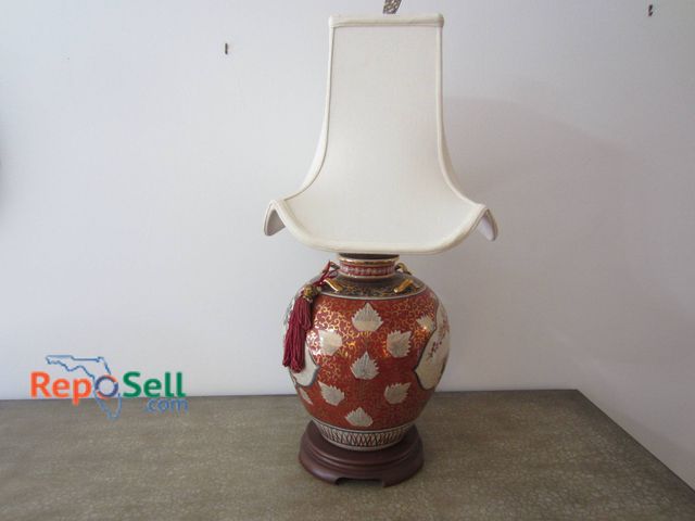 Lot 31-9121 - Porcelain Lamp Featuring Oriental Design, Wood Base, Tassel Accent, And Fabric Shade.