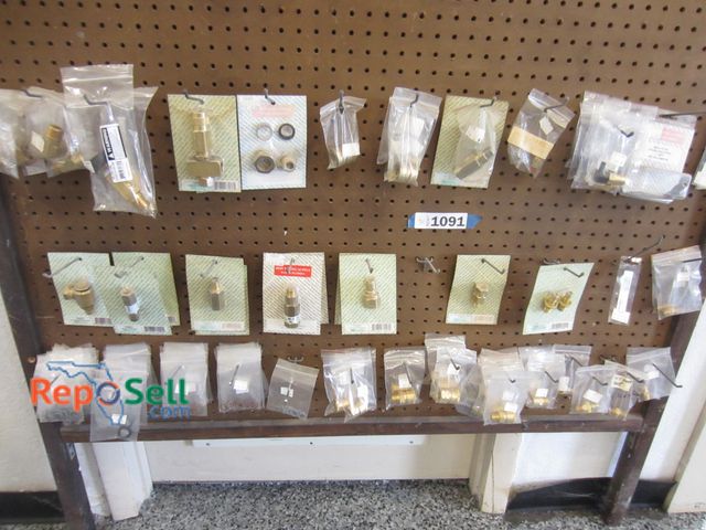 Lot 31-1091 - New brass pressure washer parts, quick attachments, O-rings, etc. - items on pegboard