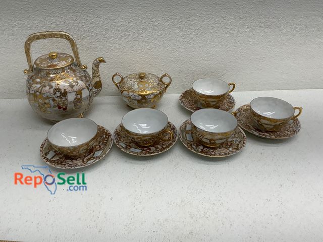Lot 31-1404 - Japanese porcelain tea set featuring hand-painted gold accents and traditional motifs. Includes one ...