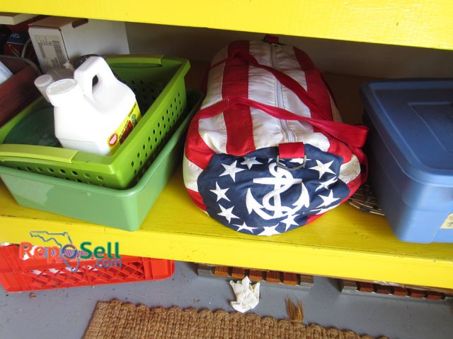 Lot 31-9146 - Contents of 2 Shelves: including a duffel bag with a flag design featuring stars, stripes, and an an...