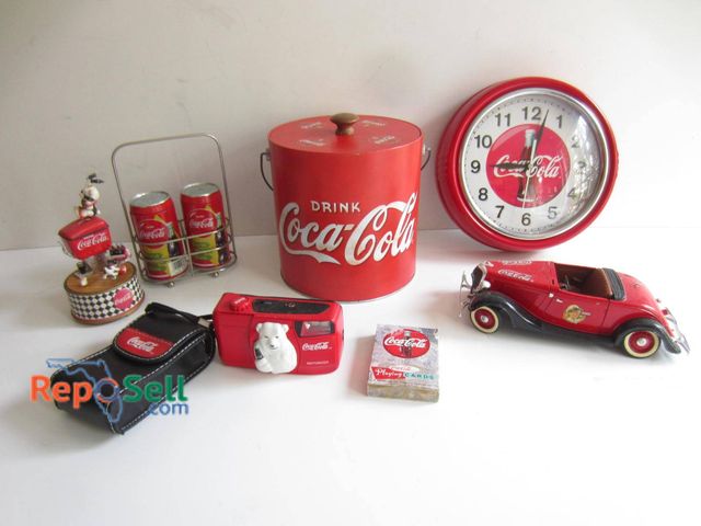 Lot 31-9150 - Coca-Cola-themed items including a wall clock, metal drink cooler with lid, miniature model car, bra...