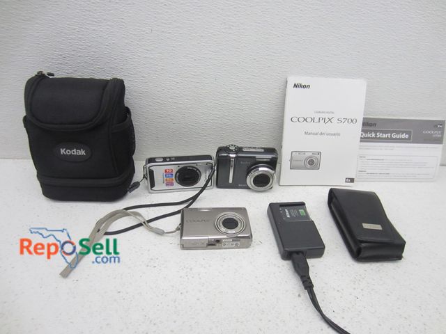 Lot 31-9469 - (3) Digital cameras and charger: Coolpix (Powers on), Kodak, Pentax.