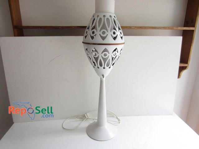 Lot 31-9309 - White-painted metal table lamp featuring a decorative cutout design on the oval-shaped body. Include...