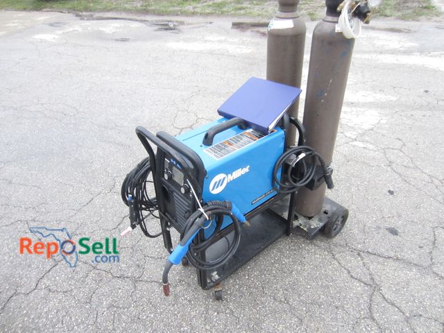 Lot 31-9285 - Miller Mig/Tig Multimatic 220 Ac/dc Welder With (2) Argon Gas Tanks And Manual - Power On. Wired for...