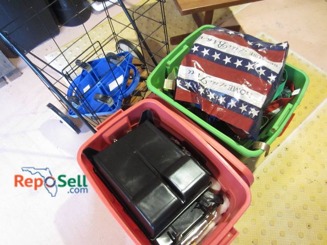 Lot 31-9217 - A black wire folding cart with wheels and handle, a green storage bin containing artificial foliage ...