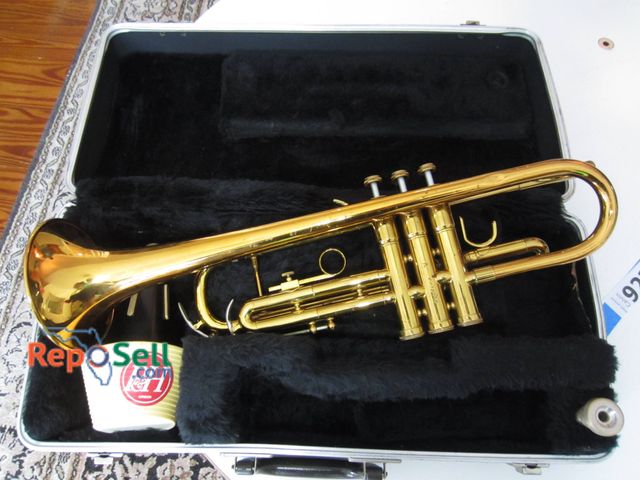 Lot 31-9228 - Conn 1000B trumpet in gold lacquer finish with three pistons, featuring engravings on the body indic...