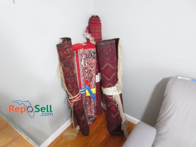 Lot 31-9020 - (5) Rolled Rugs In Various Sizes, Patterns, And Colors In Red And Multicolor Tones.