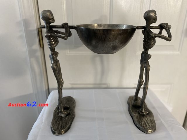 Lot 44-3632m - Metal skeletons carrying a pot. Decor or candy dish. Approximate size is 16” H X 17” W. See photos. E-Commerce Return, A basic inspection ha...