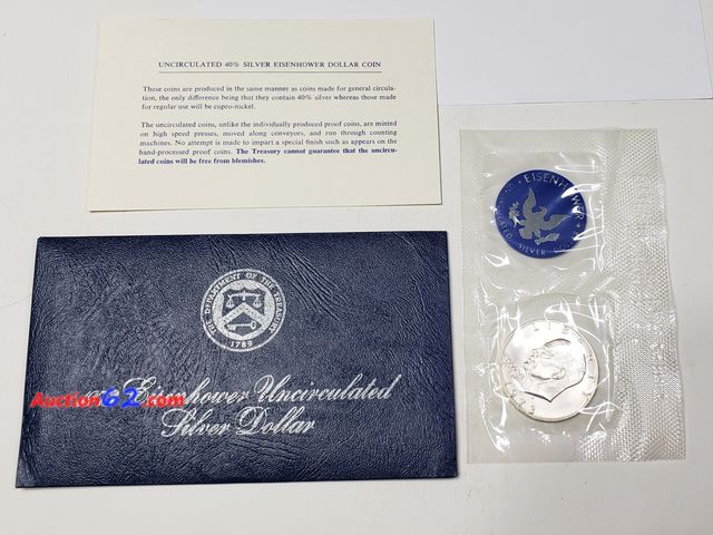 Lot 44-8332g - 1973-S EISENHOWER UNCIRCULATED 40% SILVER DOLLAR WITH CERTIFICATE OF AUTHENTICITY. KNOWN AS A "BLUE" IKE, MINTED BY THE UNITED STATES MINT. ...