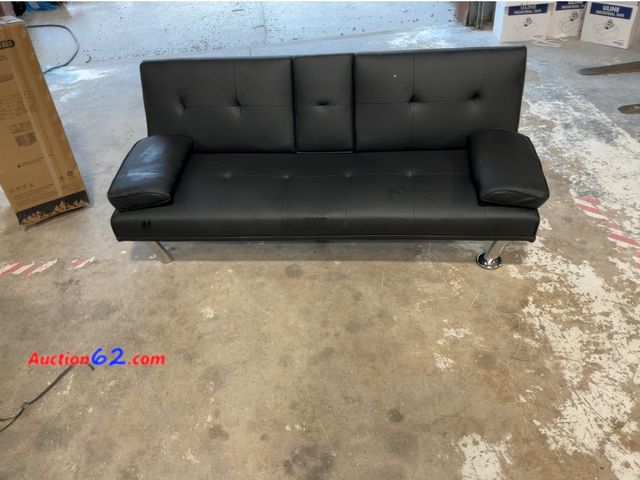 Lot 44-1505p - Black Faux Leather Futon Sofa Bed - Convertible, Tufted, Fold-Down Cupholder Console- one leg needs screwed back on  E-Commerce Return, A ba...