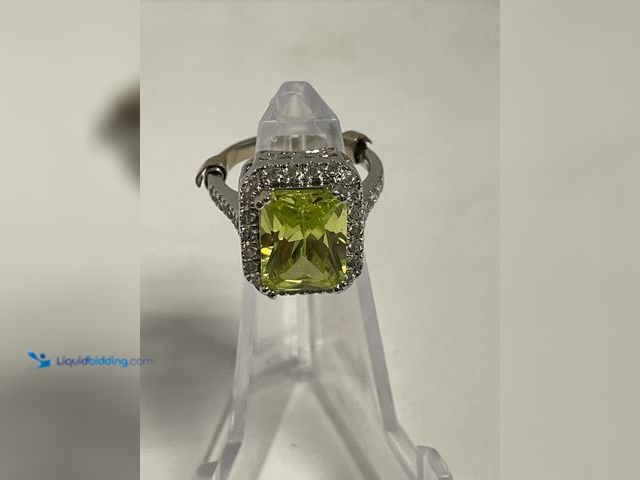 Lot 49-910576 - Sterling Silver Ring with Lime Green Center Stone & Halo Setting featuring a striking emerald-cut li...