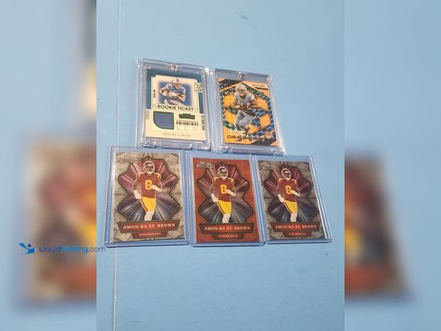 Lot 49-1817768 - 5- COLLECTIBLE AMON RA ST BROWN NFL FOOTBALL CARDS. INCLUDES ROOKIE TICKET JERSEY CARD, REFRACTOR AN...