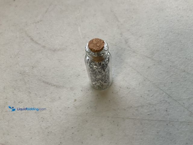 Lot 49-1804565 - ONE INCH GLASS VILE OF PURE SILVER FLAKES.