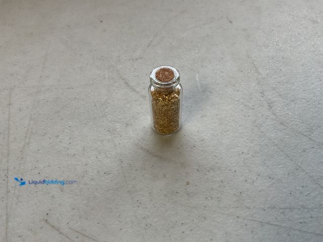Lot 49-1804563 - ONE INCH GLASS VILE OF PURE 24KGOLD FLAKES.