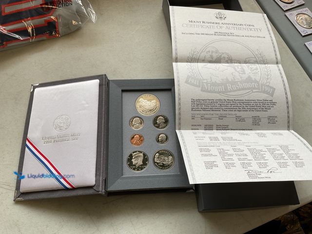 Lot 49-1505497 - 1991 UNITED STATES MINT PRESTIGE SET MT RUSHMORE ANNIVERSARY COINS 7 COINS INCLUDING ONE TROY OZ SIL...