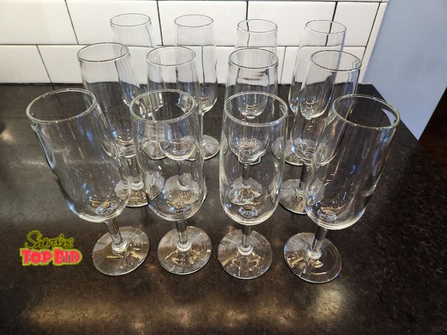Lot 59-97005 - 12 glass champagne flutes. Shorter than standard flutes - easier to fit in a kitchen cabinet! No chi...