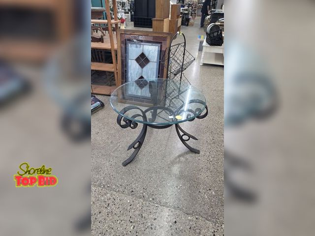 Lot 59-95002 - OFFSITE  Glass top patio table  Some rust on legs 26 in tall 35 in width
