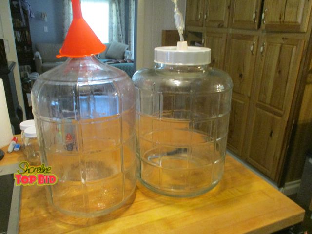 Lot 59-92048 - 2 wine fermenting jugs 6 gal and 5 gal. the wide mouth is the easiest to use. with funnel. you would...