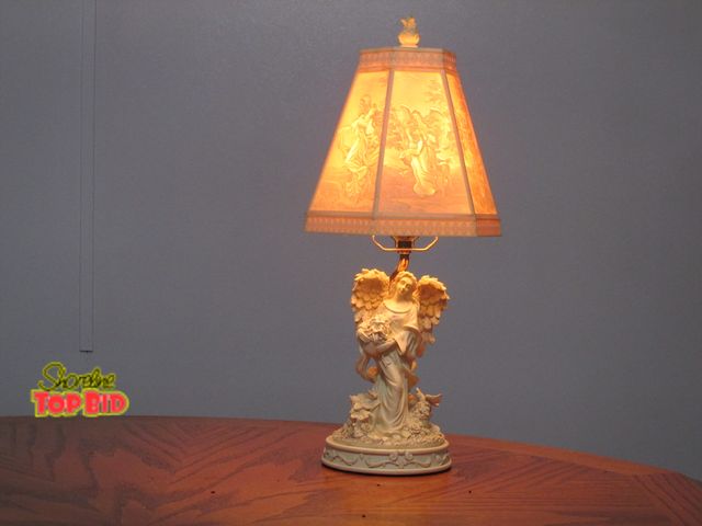 Lot 59-10092 - 17"T decorative lamp with an angel holding a bouquet of flowers.  When the light is on the shade is ...