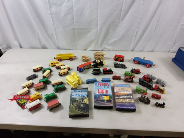 Lot 7-119817 - Lot of miscellaneous train toys, figurines, and vhs tapes.