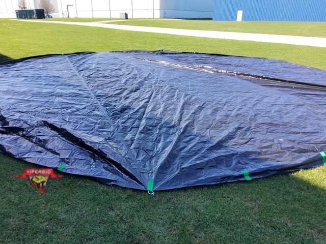Lot 7-130379 - Round Black Pool cover with stakes and rope. Overall diameter is about 36 ft. Cover is new but taken...