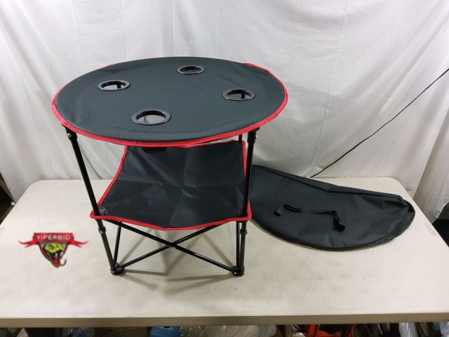 Lot 7-132979 - Portable camping / tailgating table with shelf and storage bag Easy up / down. 28" Dia. X 24"H.