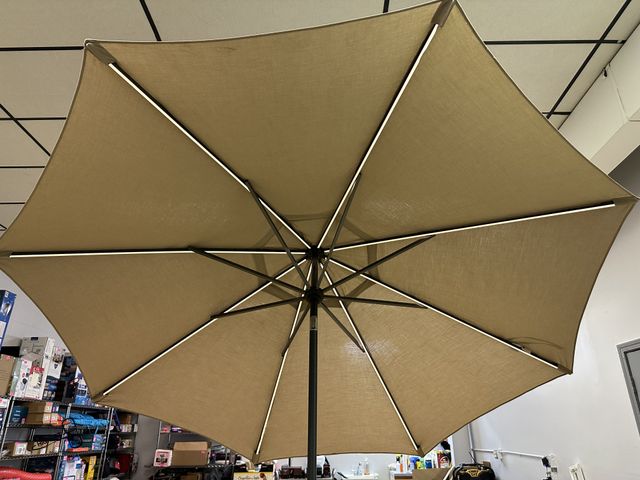 Lot 91-6599 - SUNVILLA 10' ROUND SOLAR LED MARKET UMBRELLA - TAN - LIGHTWEIGHT, STURDY, AND RUST RESISTANT ALUMINU...