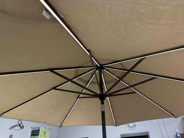 Lot 91-6596 - SUNVILLA 10' ROUND SOLAR LED MARKET UMBRELLA - TAN - LIGHTWEIGHT, STURDY, AND RUST RESISTANT ALUMINU...