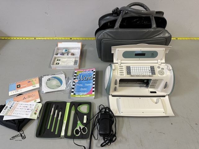 Lot 91-7100 - CRICUT MACHINE WITH CUTTING SUPPLIES, CARTRIDGES, AND A CARRYING BAG