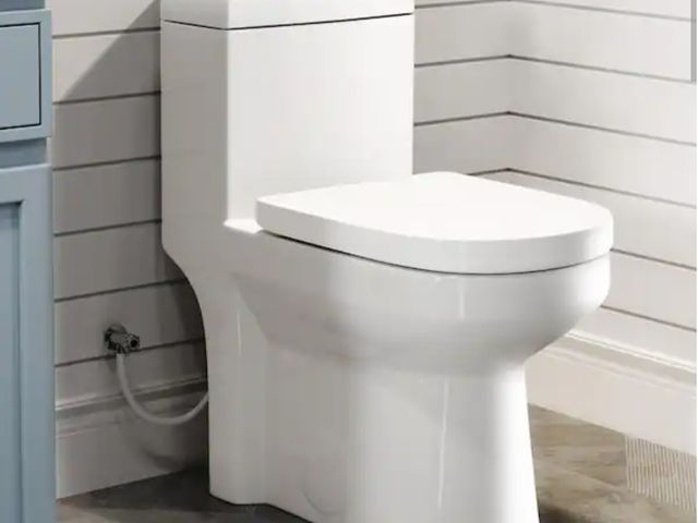Lot 96-173616 - Hanikes 
One-Piece 1.1/1.6 GPF Dual Flush Round Toilet in White Soft Close Seat Included New MSRP $2...