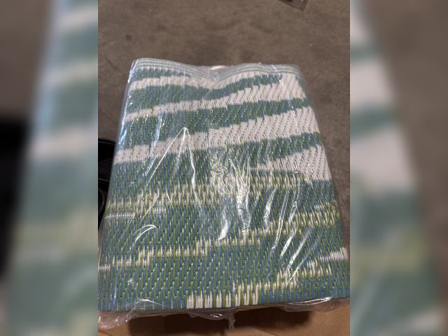 Lot 96-233172 - Appears to be an outdoor rug. Approx 5x8 New.